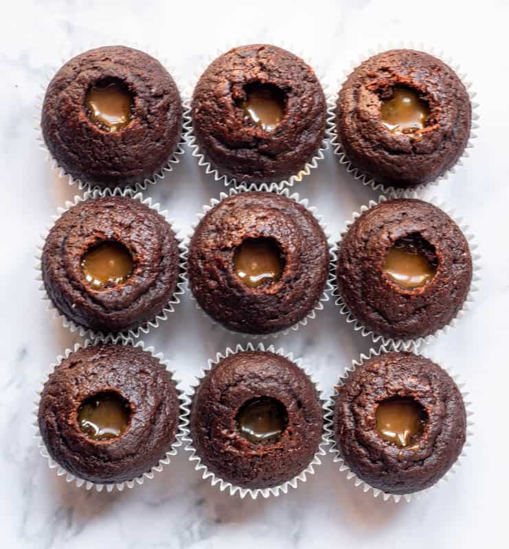 Chocolate Caramel Cupcakes being filled, sown from above with a caramel centre and no icing yet 