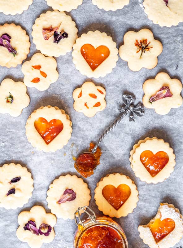 Shortbread Style Jam Sandwich Cookies on a baking tray after being baked. Shown with jam inside 