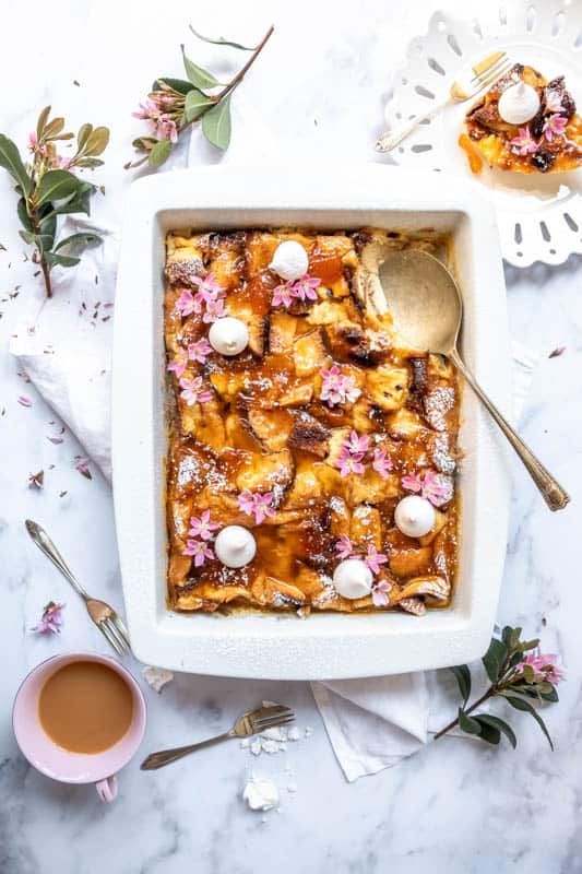 Easy Apricot Brioche Bread Pudding shown from above with flowers and mini meringues on the dessert 