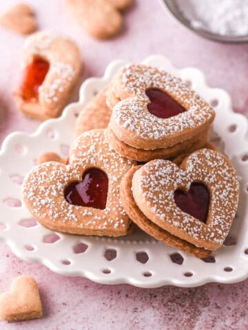 Jam filled cookies shown on a heart plate.