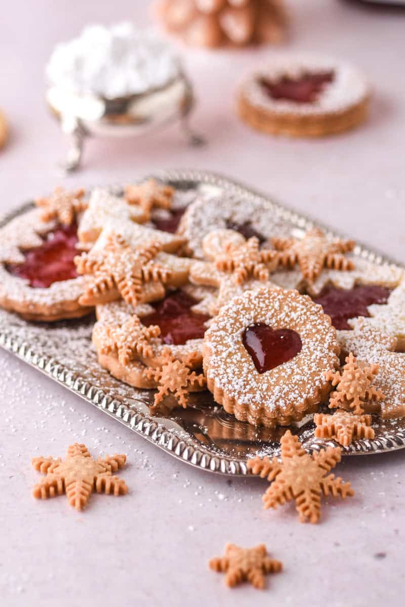 Christmas Butter Cookies shown on a silver tray, some are filled with jam and some are plain.