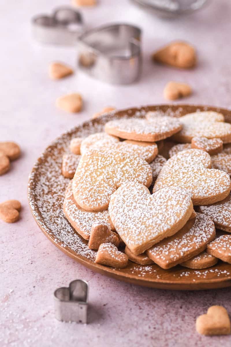 Valentines cookies dusted with powdered sugar on a plate. 